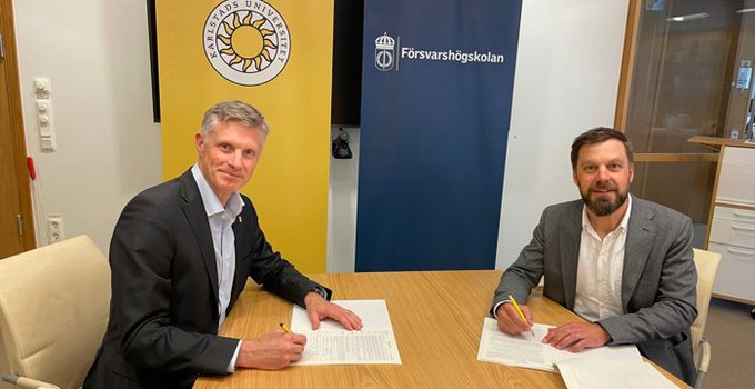 Två män skriver under avtal