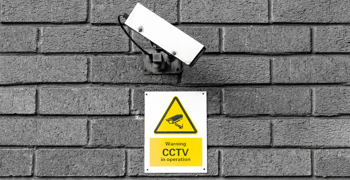 Bild av en övervakningskamera mot en tegelvägg.