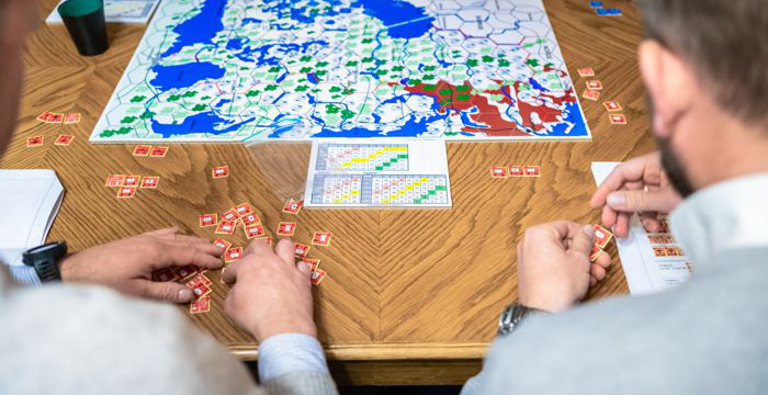 Personer sitter vid ett bord och spelar brädspel.