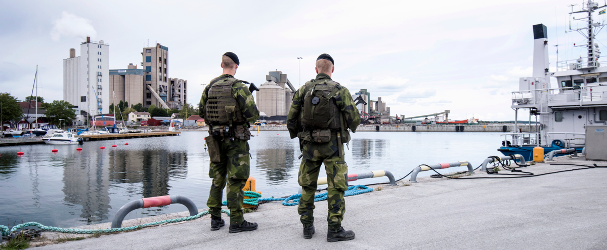 Två militärer som står på en kaj.