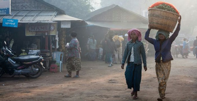 Två kvinnor som går på en väg i Myanmar.