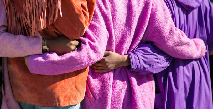 Kvinnor som håller varandra om ryggen.