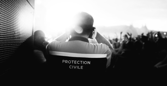 Ryggen av en ordningsvakt framför en folkmassa.