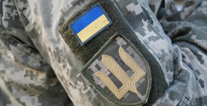 En närbild av en militäruniform med en ukrainsk flagga på.