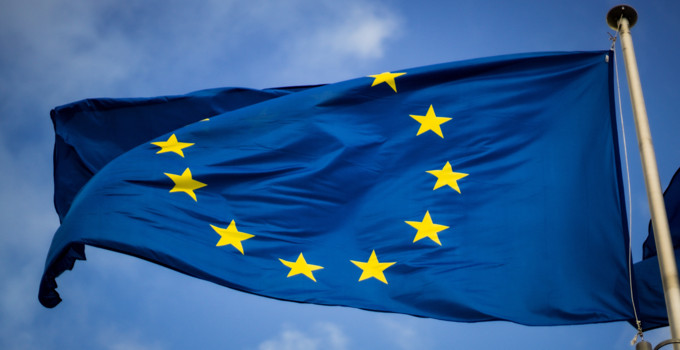 En blå och gul EU-flagga som vajar i vinden.