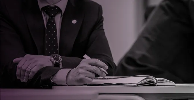 Crossed arms at a table.