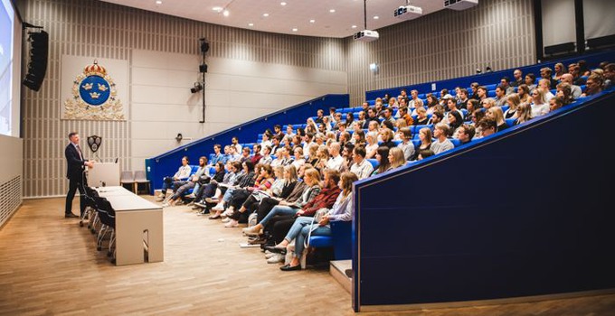 Rektor talar till studenter i Sverigesalen.