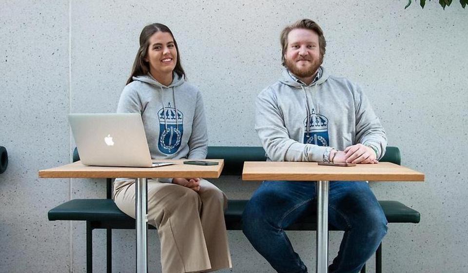 Studentambassadörer vid ett bord i entréhallen.