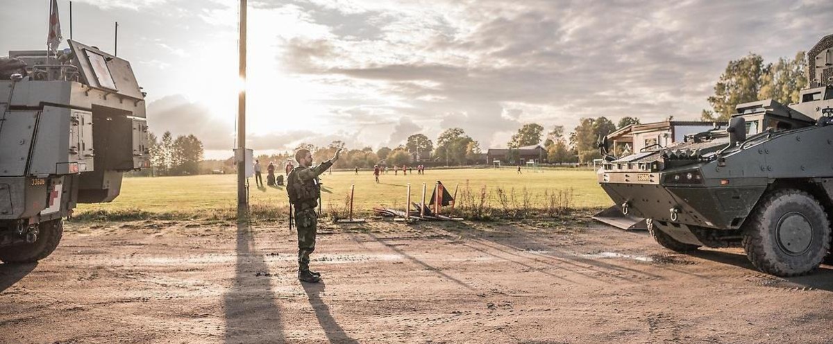 Soldat stoppar stridsfordon under övning.