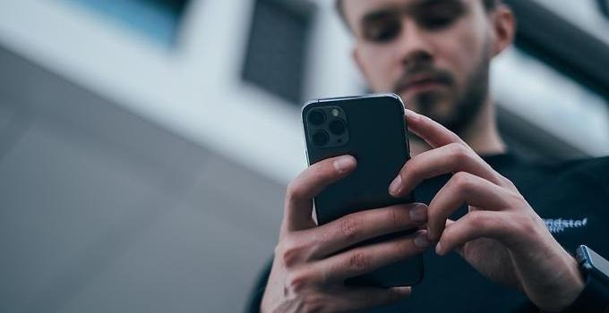 Närbild på en man som tittar på en smartphone.