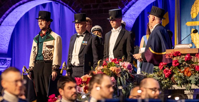 Fyra personer i hatt och högtidsdräkt.