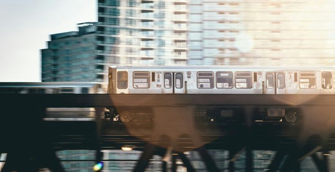 Pendeltåg framför höghus.