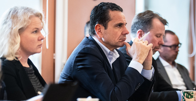 En grupp människor som sitter vid ett bord med bärbara datorer.