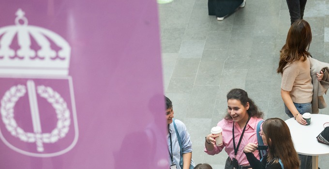 Glada studenter i entréhallen med FHS-fana i förgrund