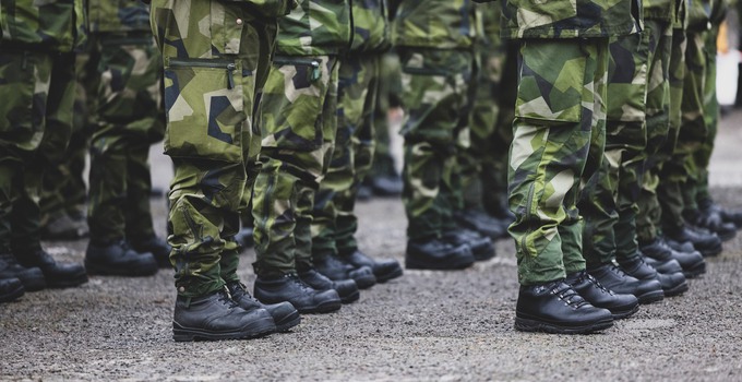 Soldaters ben och kängor i uniform.