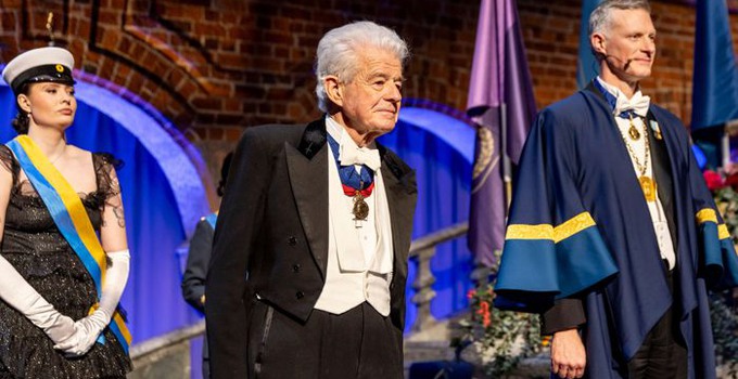 Tre personer i Stadshuset vid en ceremoni.