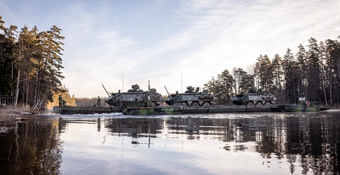 Bandvagnar transporteras över vatten.