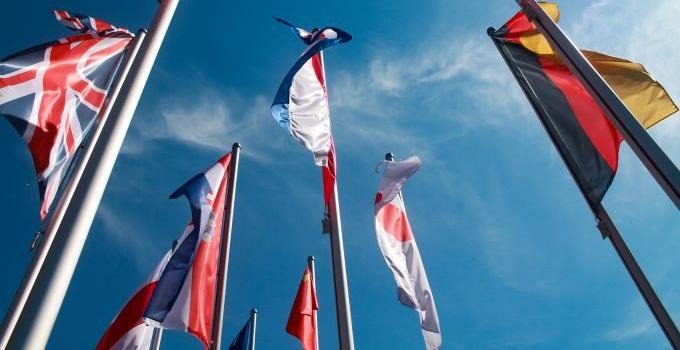 Olika länders flaggor fotograferade mot en blå himmel.