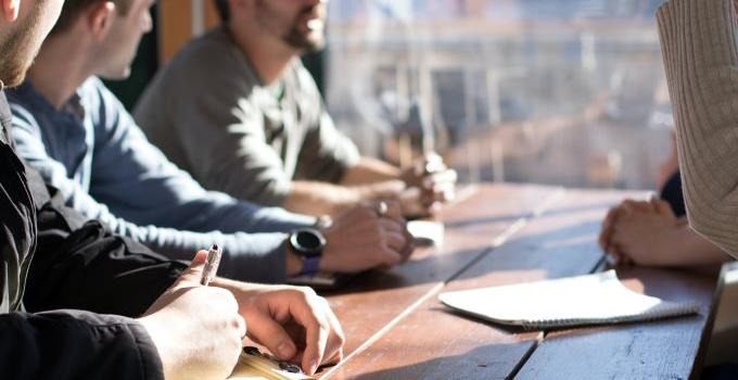 Närbild på personer som arbetar vid ett bord.