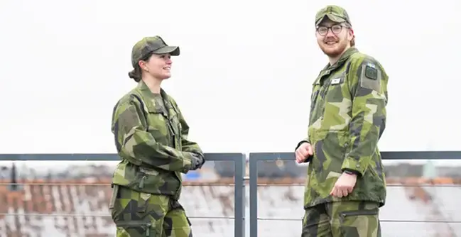 Två kadetter stående på Försvarshögskolans tak.