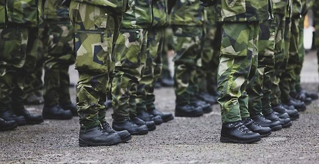 Soldaters ben i uniform och kängor 