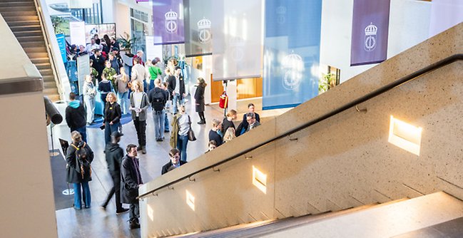 Personer som minglar i FHS entréhall.
