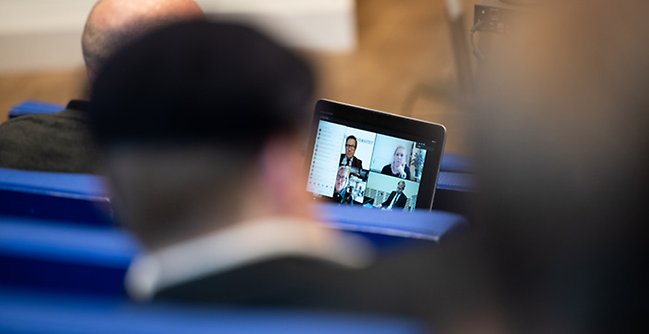 Person i föreläsningssal som tittar på en skärm.