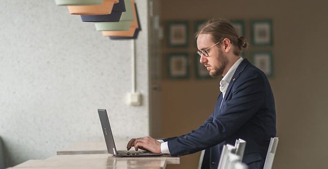 Studet skriver på laptop.