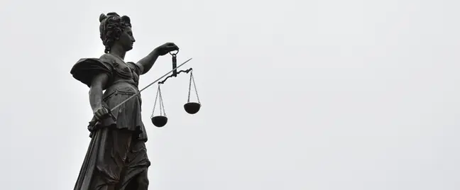 A statue of lady justice holding a scale of justice.